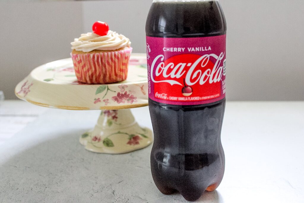 Cherry Vanilla Coca-Cola Cupcake with bottle of Cherry Vanilla Coca-Cola.