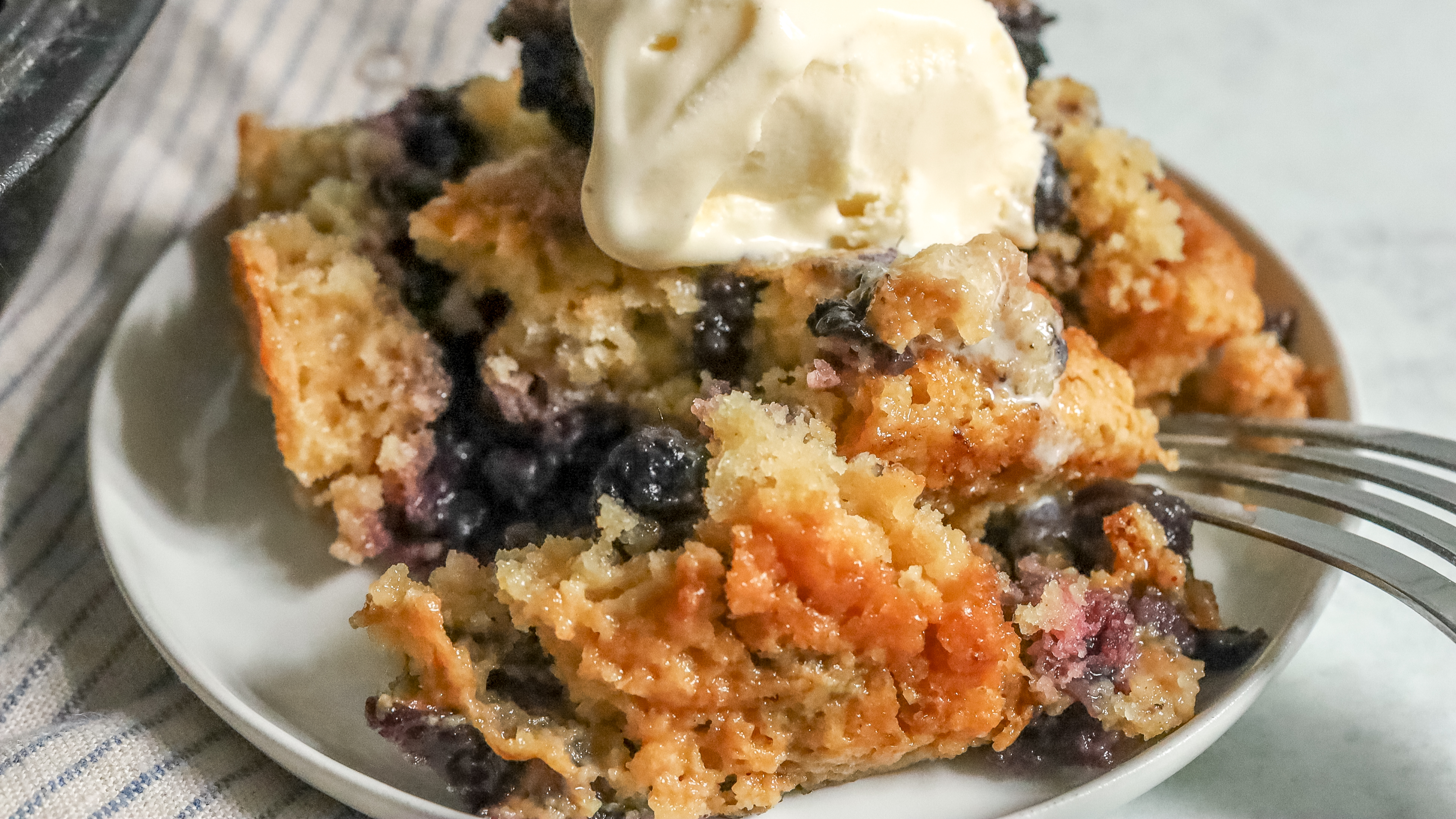 close up on mixed berry cobbler with vanilla ice cream