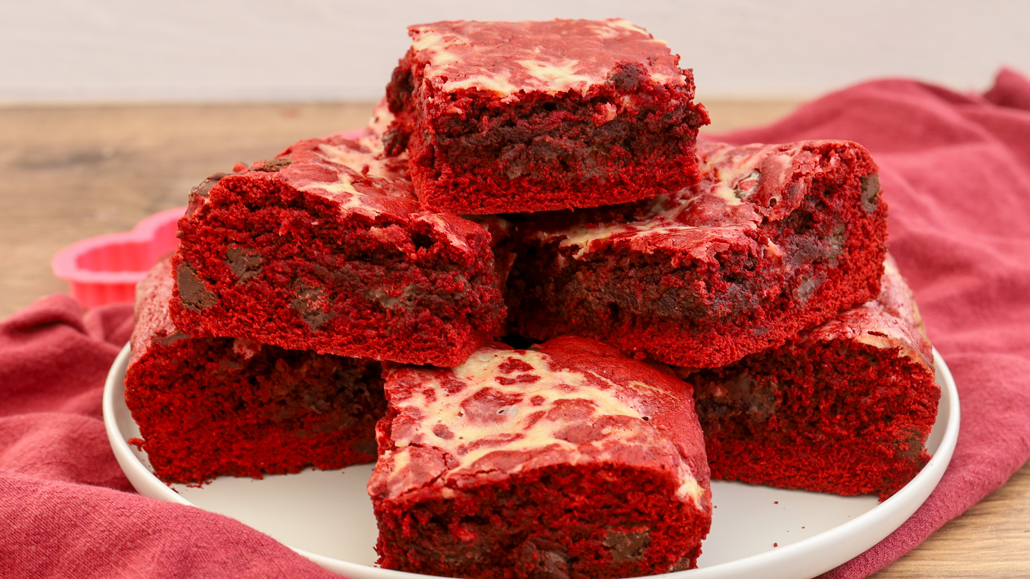 stacked red velvet cheesecake brownies on a plate